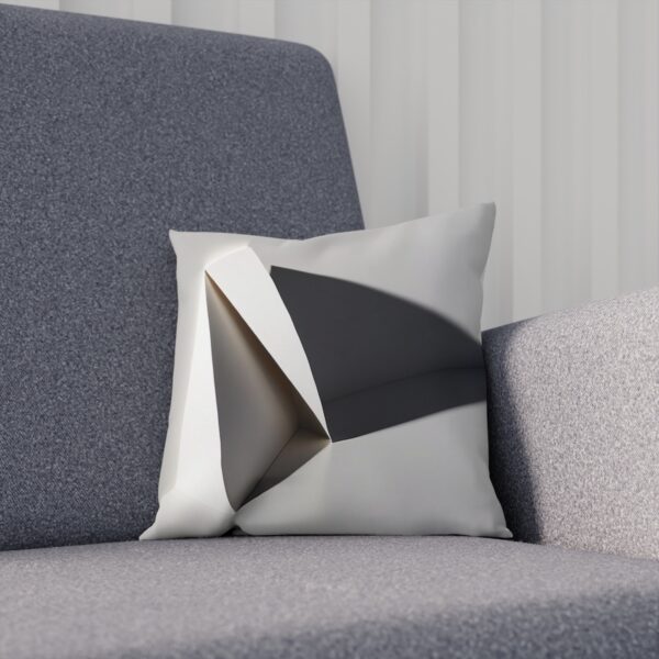 Minimalist cushion with grayscale folded paper design on chair