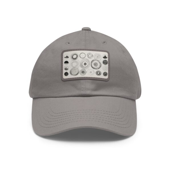 Dad Hat with stitched patch featuring a geometric design of various-sized circles and triangles in neutral tones.