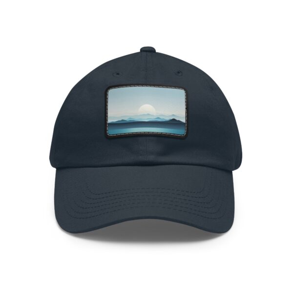 Dad Hat with stitched patch featuring a minimalist landscape of mountains with a large rising sun in soft blue tones.