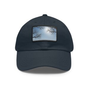 Dad Hat with stitched patch featuring a minimalist design of tree branches framing a cloudy sky.