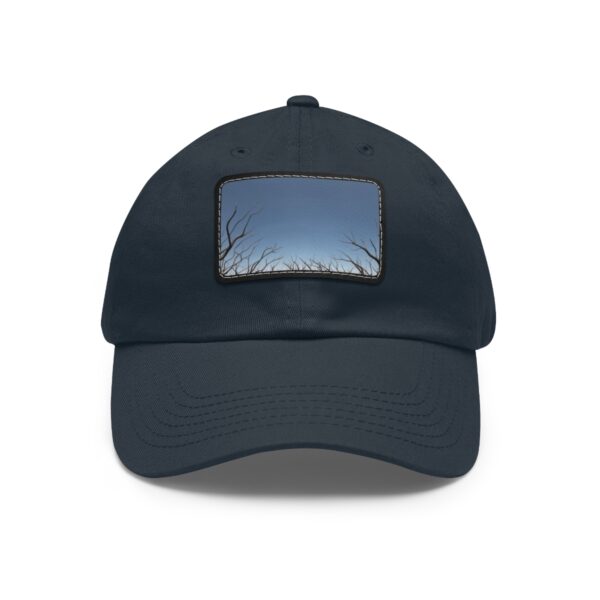 Dad Hat with stitched patch featuring a minimalist design of bare tree branches reaching towards a twilight sky.