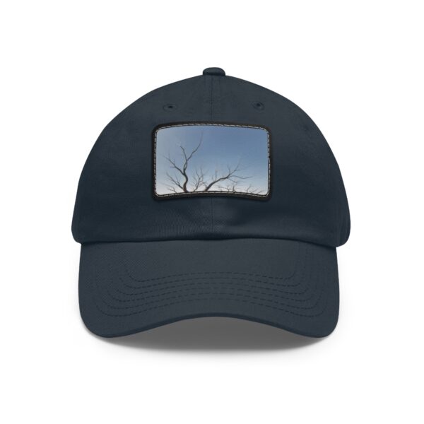 Dad Hat with stitched patch featuring a minimalist design of a bare tree silhouette against a clear sky.