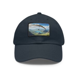 Dad Hat with rectangular patch featuring a hang glider soaring over a valley surrounded by mountains and lush greenery