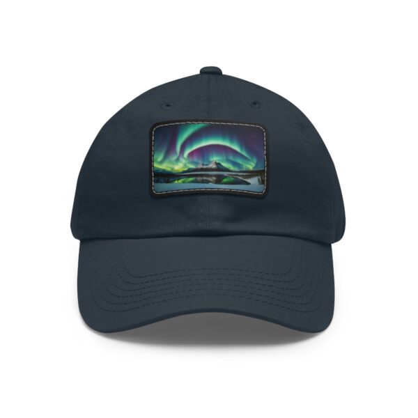 Dad Hat with rectangular patch featuring swirling Northern Lights over a tranquil Arctic landscape with reflective waters