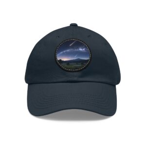 Dad Hat with round patch featuring a comet streaking across a starry sky above a peaceful open landscape