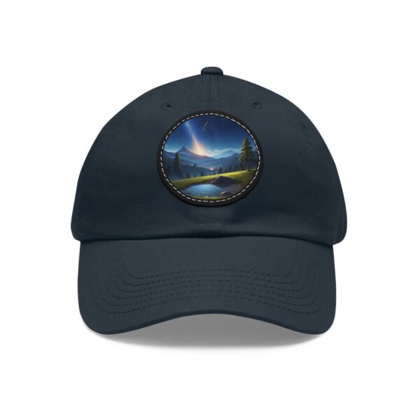 Dad Hat with round patch featuring a comet streaking across the sky above a peaceful mountain landscape with a reflective lake