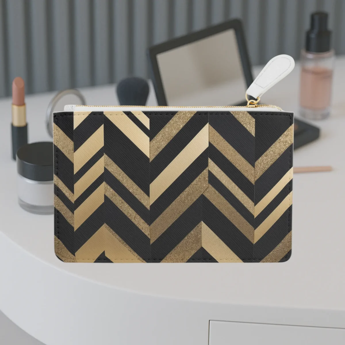 Mini clutch bag with a bold black and gold chevron pattern placed on a vanity table.