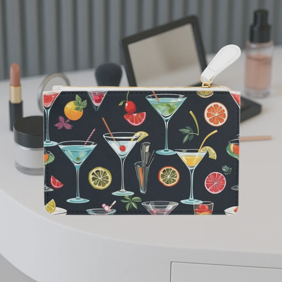 Mini clutch bag with a colorful cocktail and fruit pattern on a dark background, displayed on a vanity table.