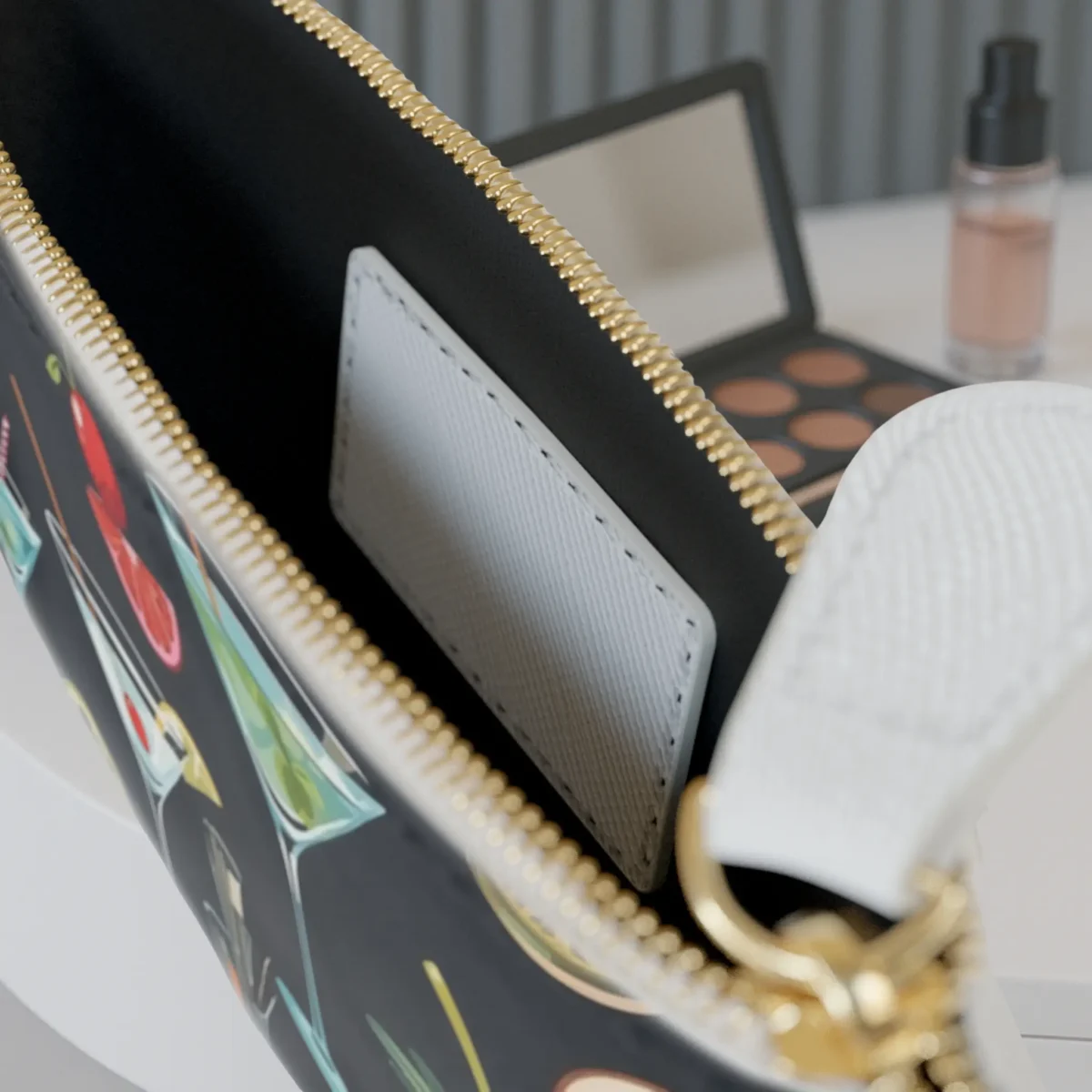 Close-up of the inside of the mini clutch bag showing the pocket and cocktail-themed print along the edge.