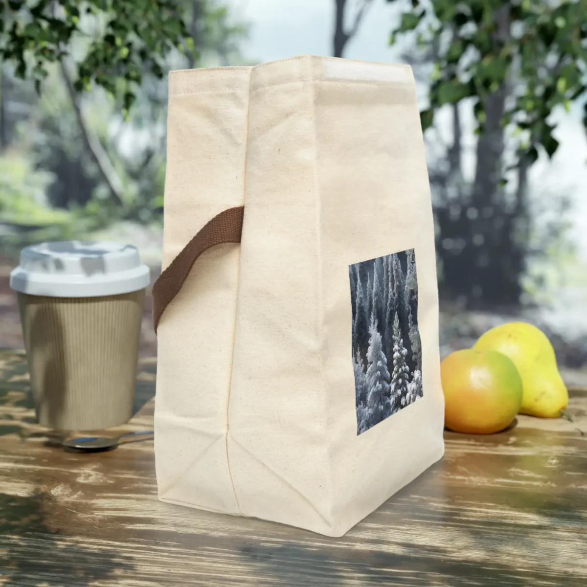 Side view of a canvas lunch bag featuring a snowy forest print with frosted evergreen trees.