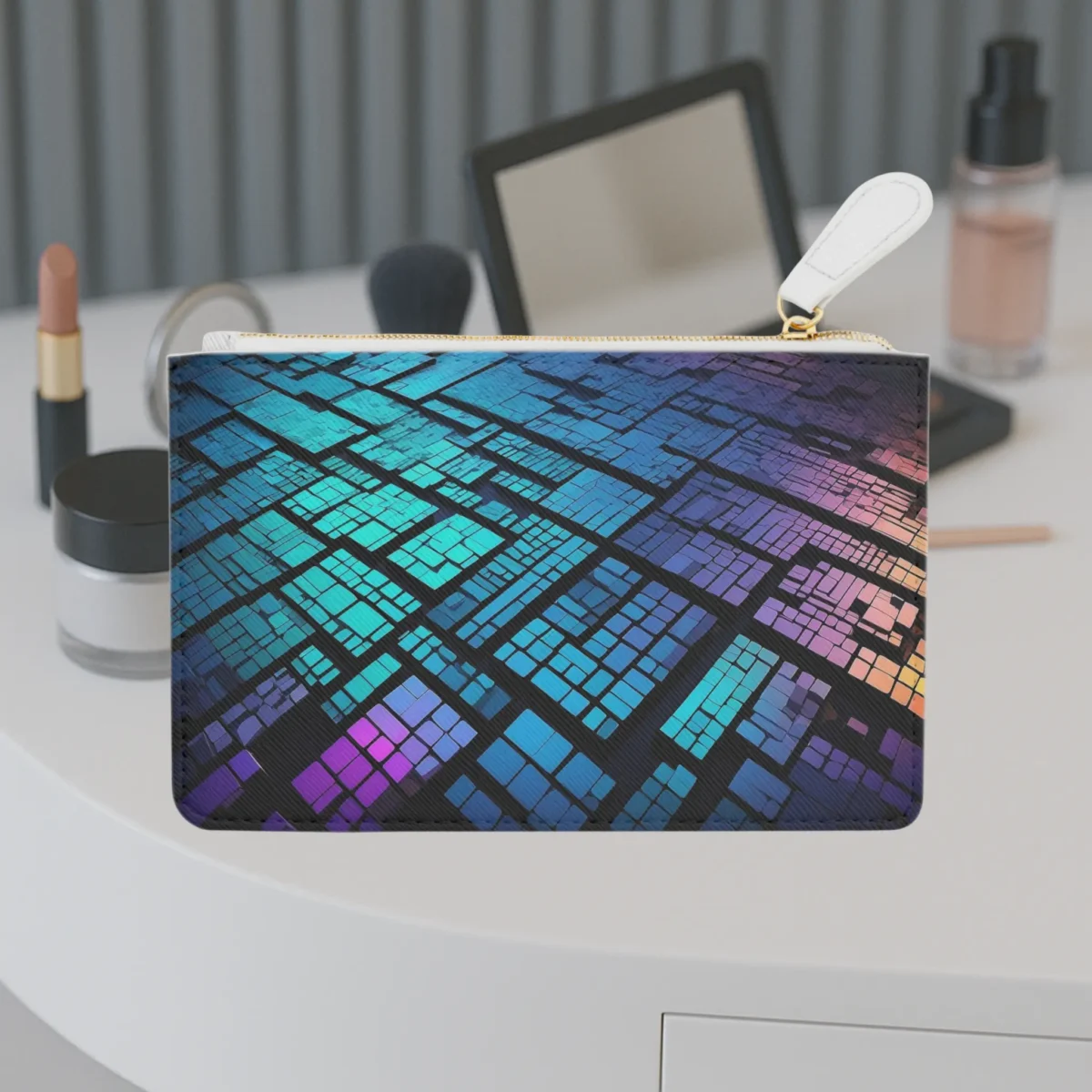 Mini clutch bag with a vibrant digital mosaic pattern in blue, purple, and orange tones, displayed on a vanity table.