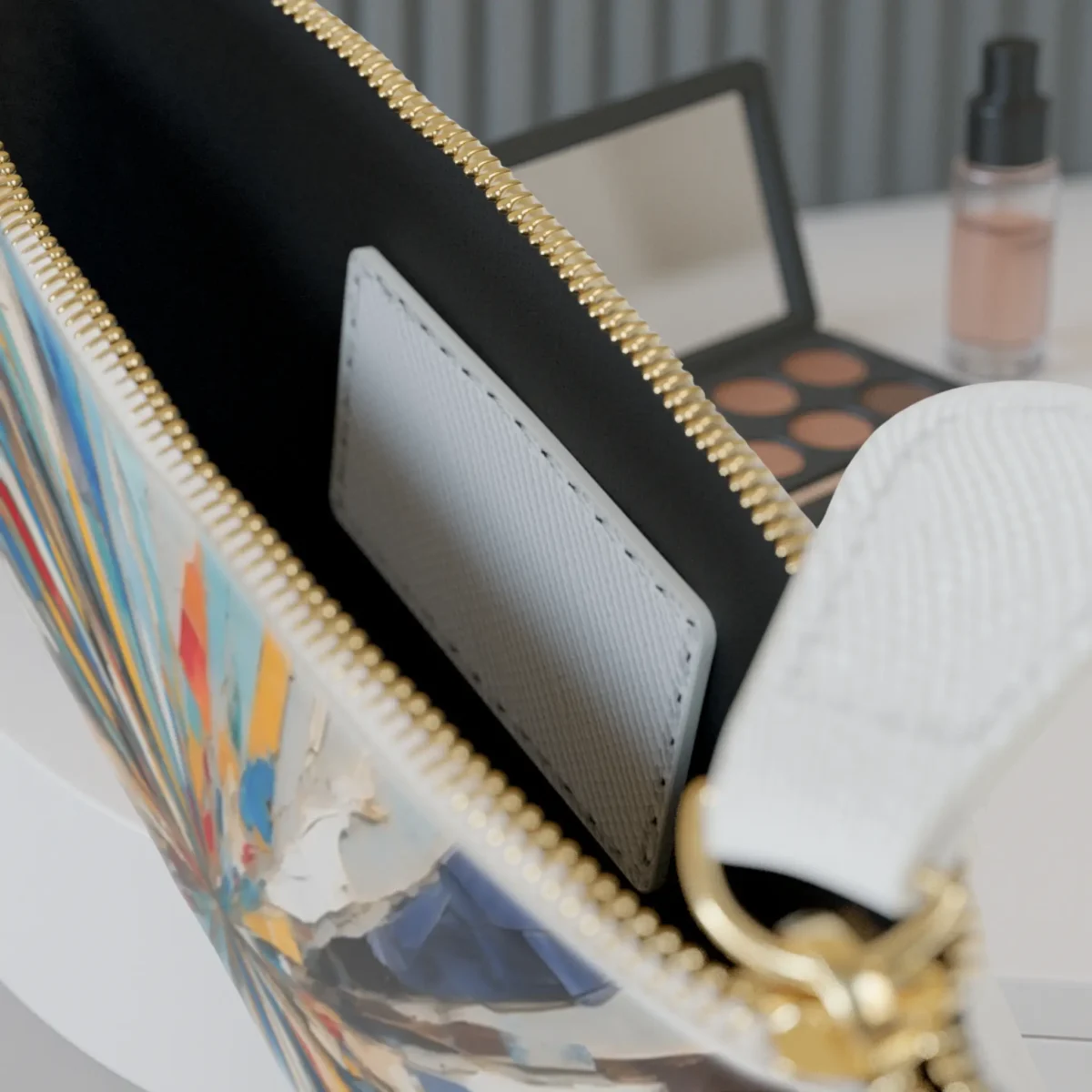 Close-up of the inside of the mini clutch bag showing the inner pocket and part of the colorful brushstroke pattern.