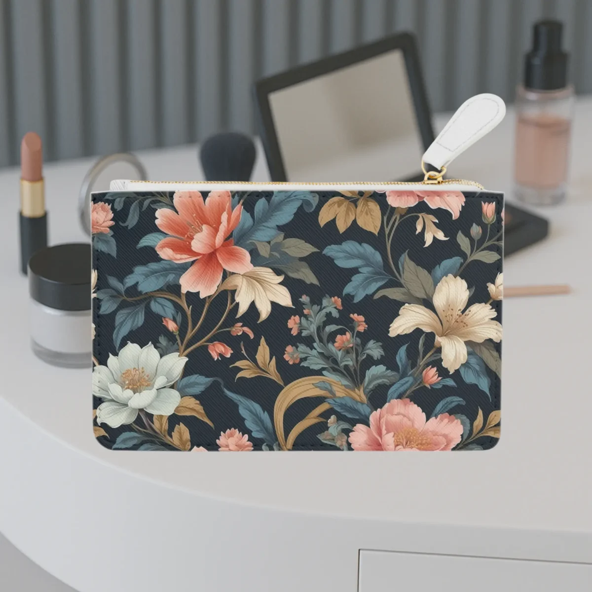 Mini clutch bag with a floral arabesque pattern in soft peach, cream, and teal tones on a dark background.