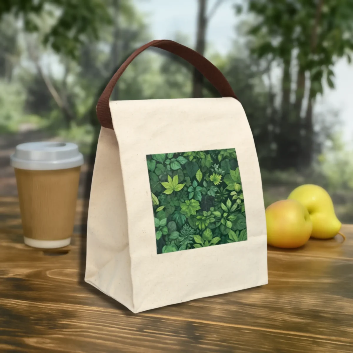 Eco-friendly canvas lunch bag with green foliage design, shown outdoors on a wooden table.
