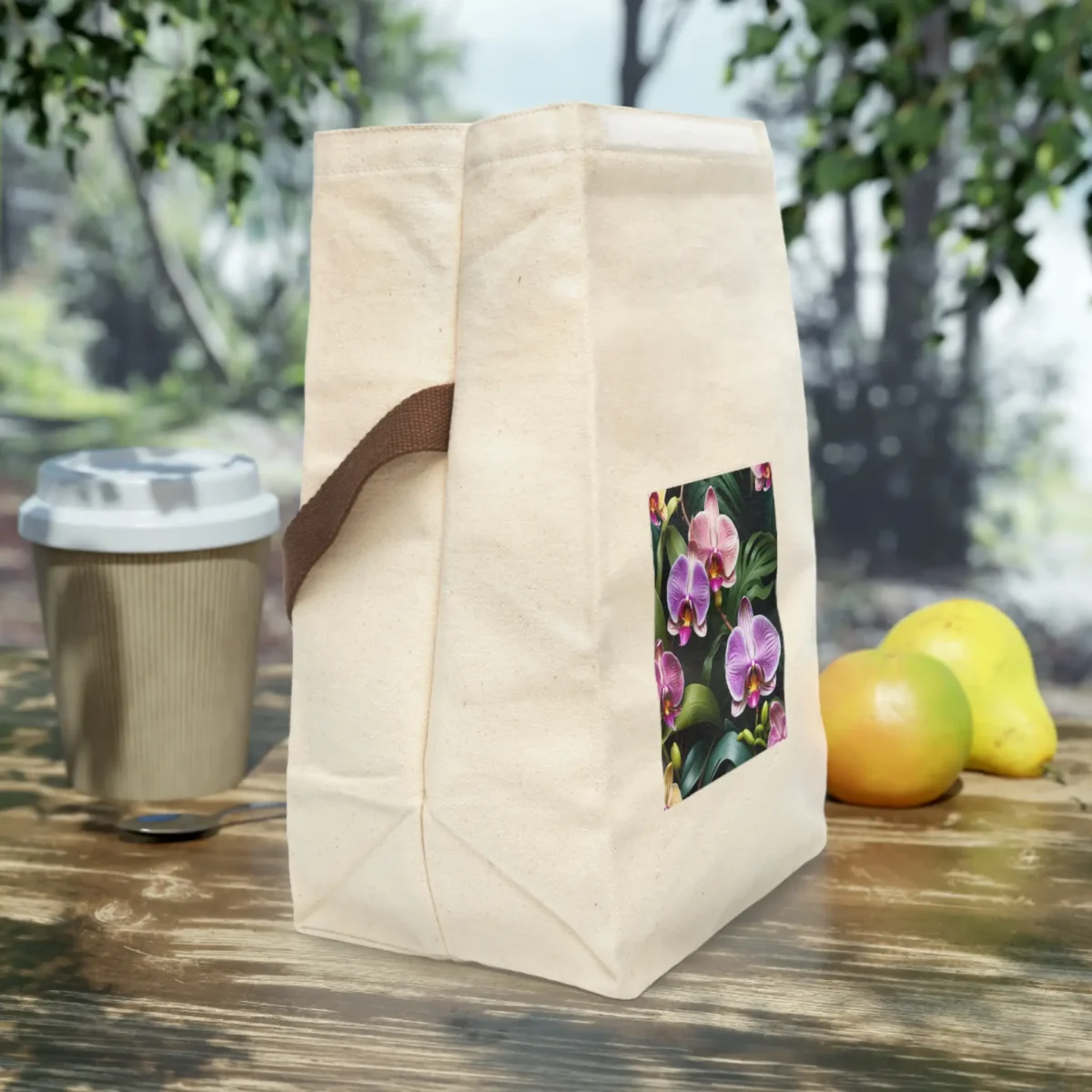 Side view of a canvas lunch bag with a vibrant orchid flower design on natural fabric.
