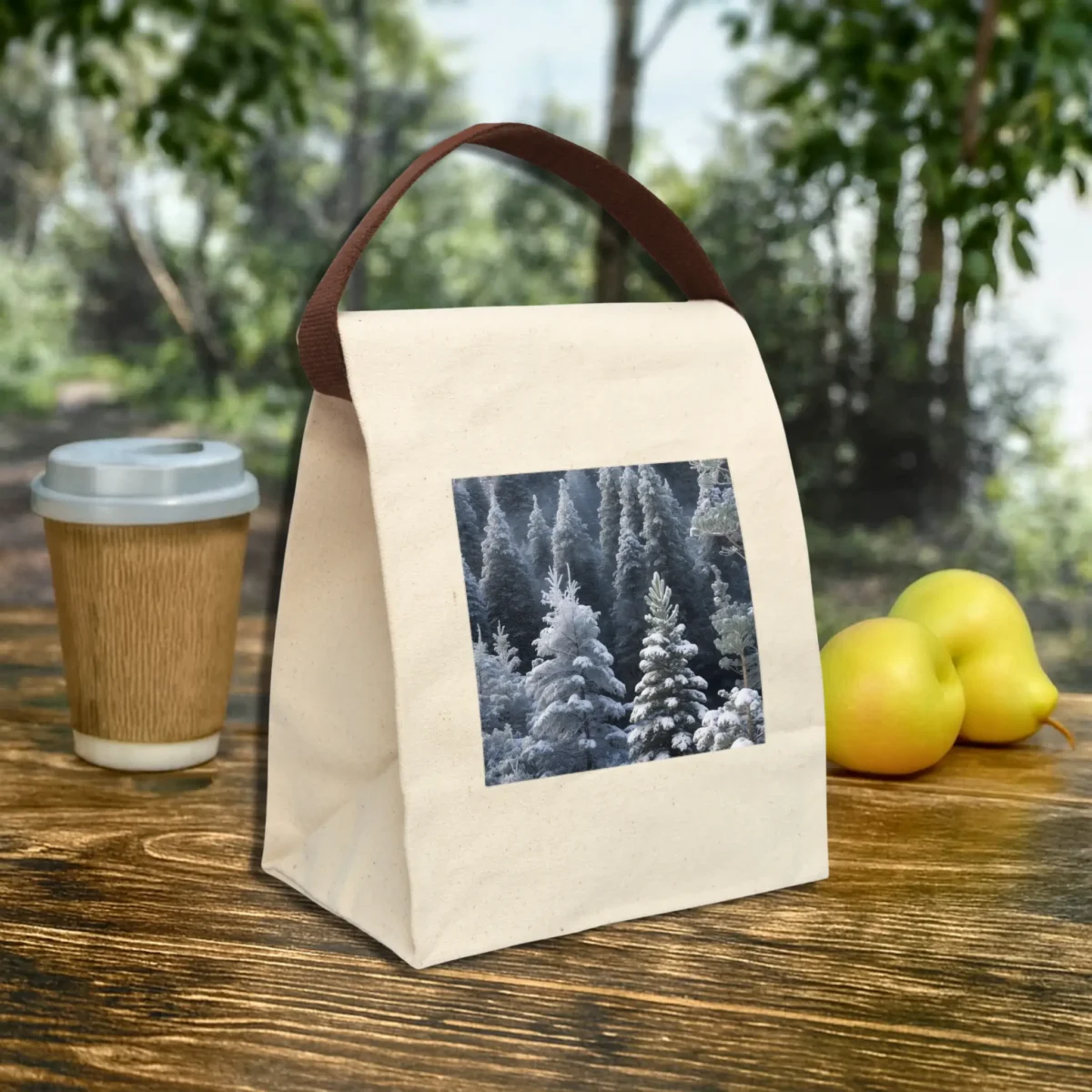 Canvas lunch bag with a snowy forest landscape print, placed on a wooden table outdoors.