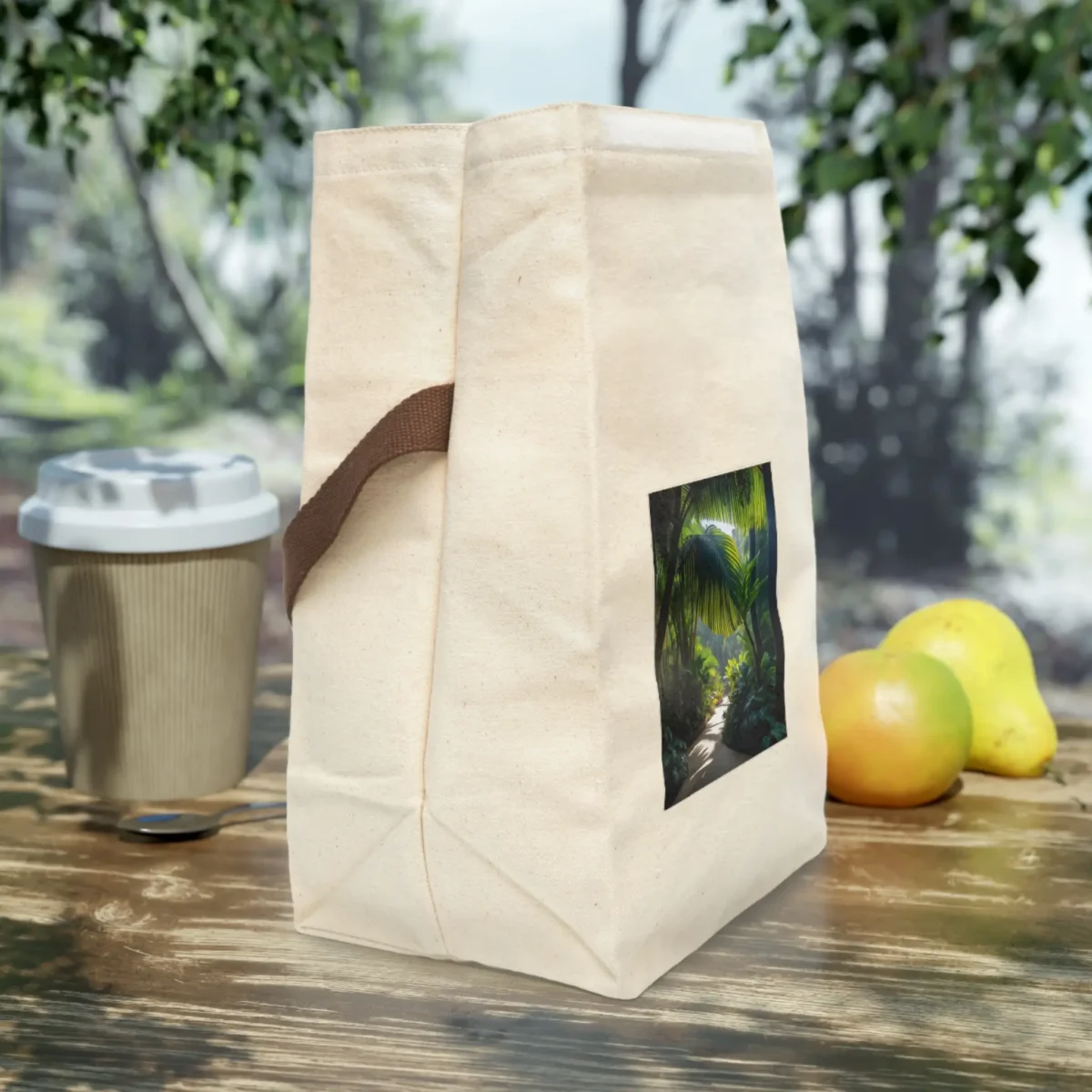 Side view of a canvas lunch bag with a tropical jungle pathway print and brown handle.