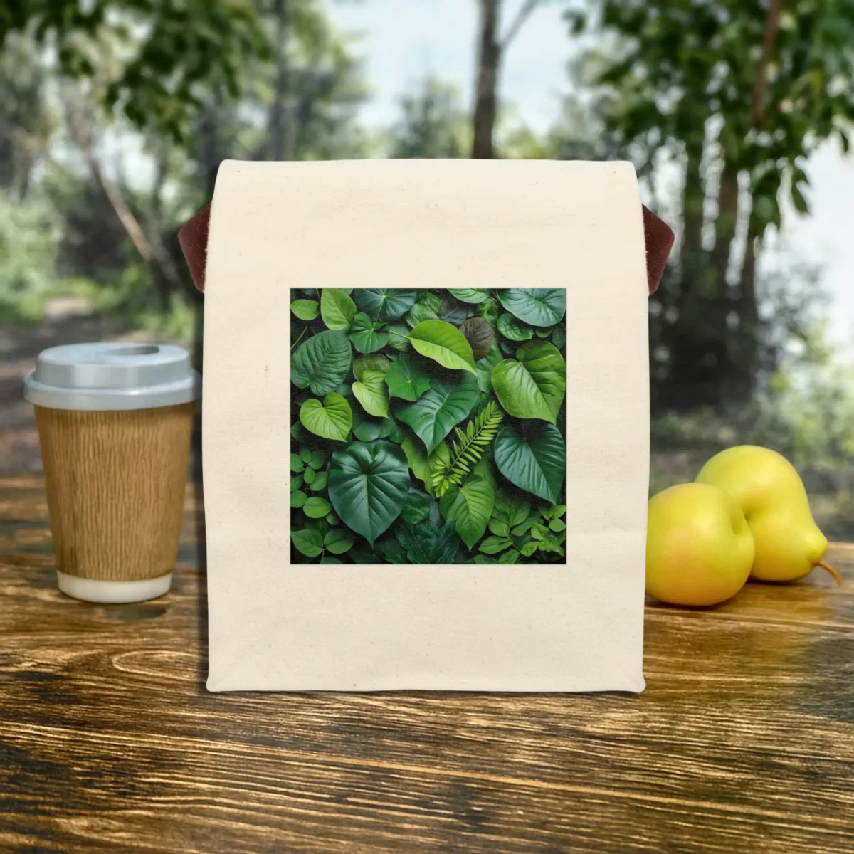 Front view of a natural canvas lunch bag with green tropical leaves design
