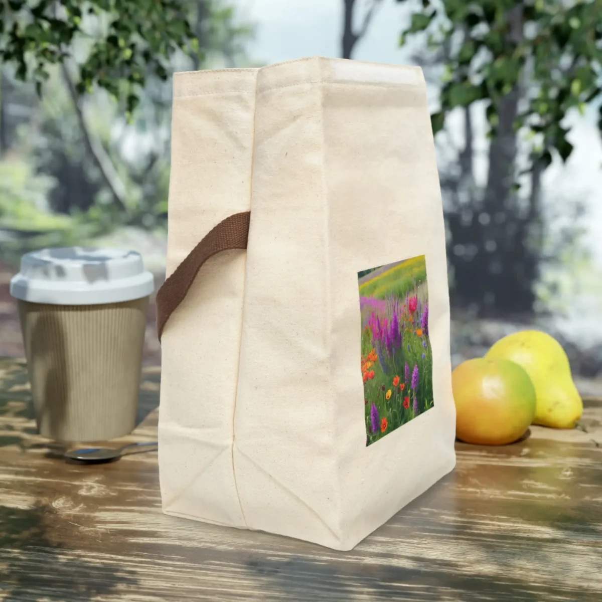 Side view of natural canvas lunch bag with wildflower meadow print and brown strap