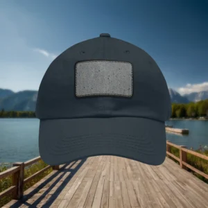 Navy blue dad hat with concrete texture patch design, displayed against a scenic lake and mountain backdrop.
