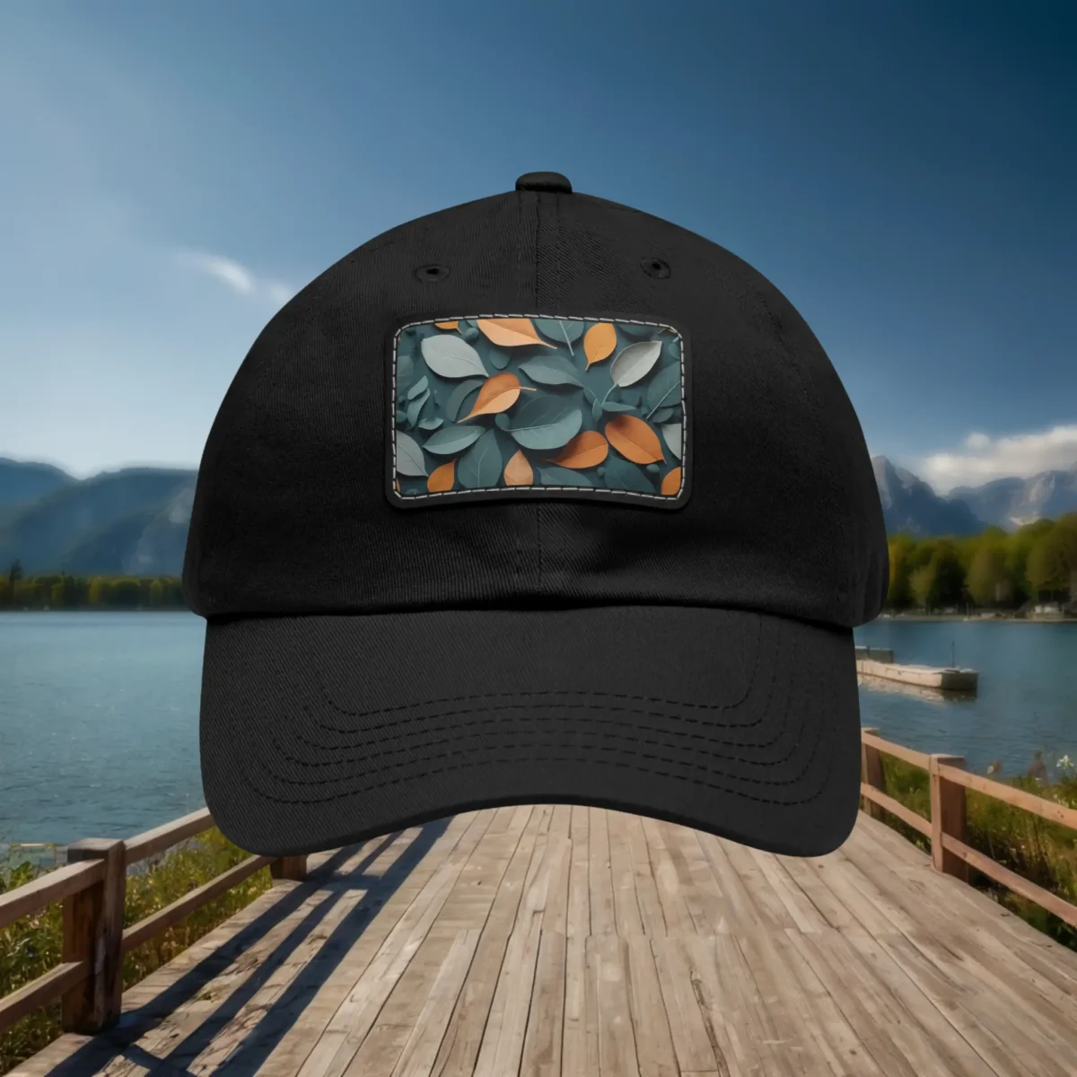 Black dad hat with a front patch featuring a decorative leaf pattern.