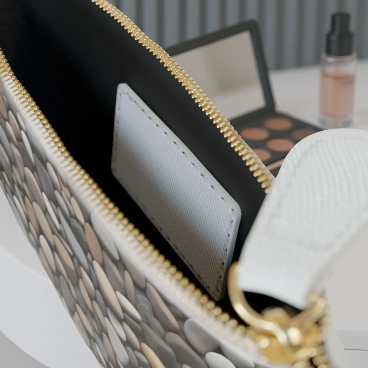 Interior of the mini clutch bag with card pocket and visible river stone print on the exterior