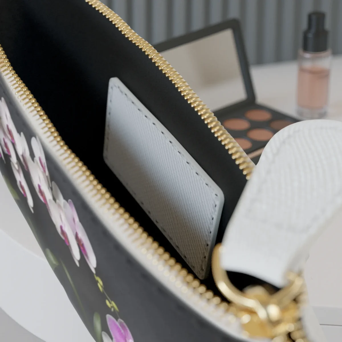 Interior of the mini clutch bag with a visible card pocket and floral print edges