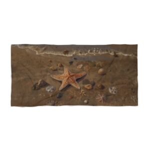 Beach towel with starfish and rocks on sandy shore near gentle ocean waves