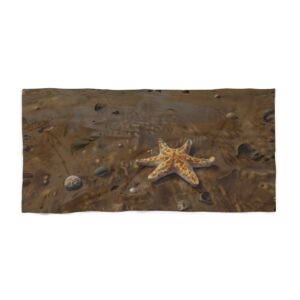 Beach towel with starfish and rocks on a sandy beach