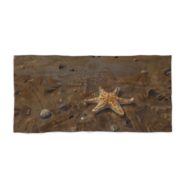 Beach towel with starfish and rocks on a sandy beach