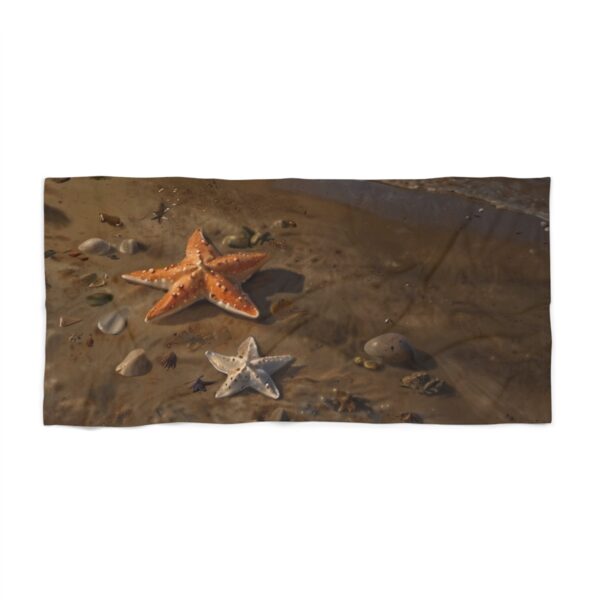 Beach towel with two starfish and rocks on a sandy shore