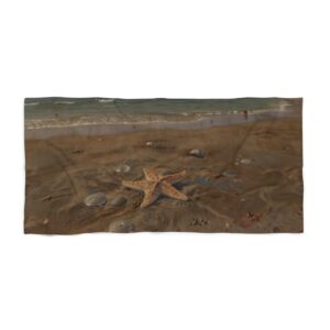 Beach towel with starfish and rocks on a sandy beach near ocean waves