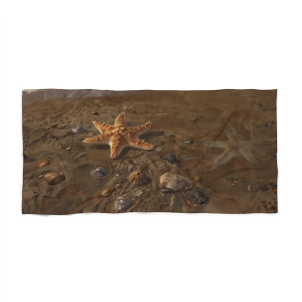 Beach towel with starfish and rocks on sandy shore