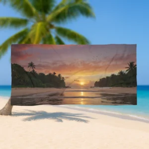 Flat view of a beach towel with a scenic tropical sunset and palm trees, held up on a beach