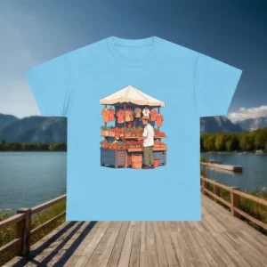 Flat lay of blue t-shirt with an artistic graphic of a busy street market stall selling produce and clothes.