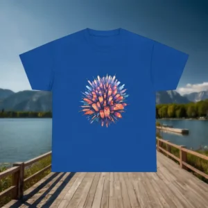 Flat lay of a royal blue t-shirt with a vibrant exploding cityscape design, displayed over a lakeside dock.