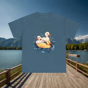 Flatlay of a navy blue t-shirt with a colorful duck family illustration, displayed over a lakeside dock.