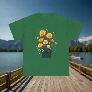 Flat lay of a green t-shirt with a graphic of yellow flowers in a black flower pot, placed on a lakeside boardwalk.