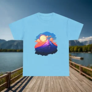 Flatlay of a light blue t-shirt with a colorful sunset and mountain illustration