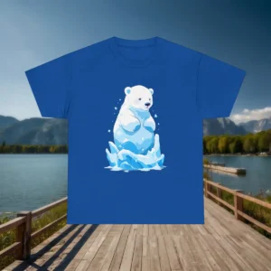 Flatlay of a blue t-shirt with a cartoon polar bear sitting on ice, surrounded by mountains and lake.