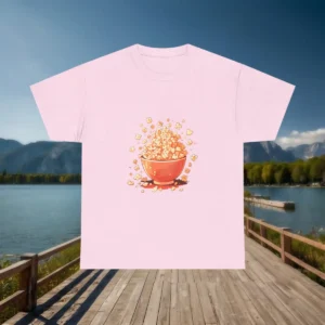 Flatlay of a pink t-shirt with a cartoon-style popcorn bowl overflowing with kernels.