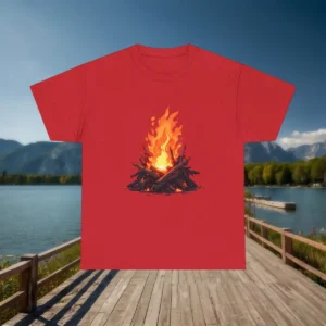 Flat lay of red t-shirt with illustrated bonfire flames, placed on a wooden pier with lake and forest in the background.