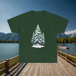 Flatlay of a dark green t-shirt with a snowy evergreen trees design, placed on a dock with a lake view.