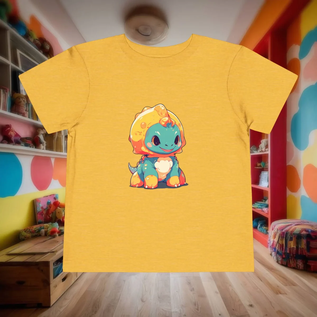Flat lay of a yellow toddler t-shirt featuring a cartoon baby Pachycephalosaurus in orange, blue, and yellow.