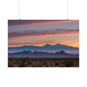 Desert landscape with distant mountains and a vibrant sunset sky, featuring soft pink, orange, and purple hues.