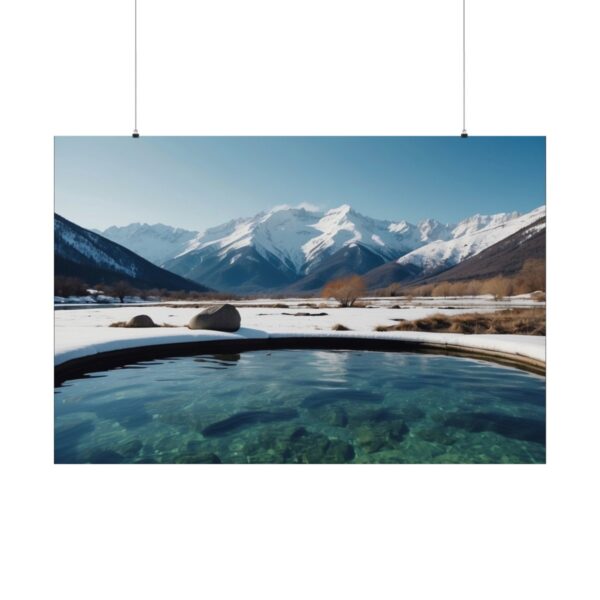 Clear mountain lake with snow-covered landscape, surrounded by towering snow-capped mountains under a bright sky.