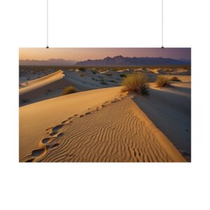 desert landscape with sand dunes, footprints, and distant mountains at sunset