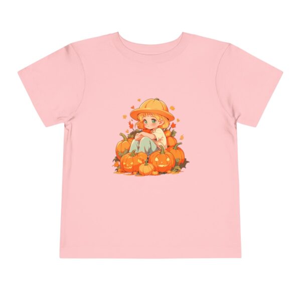 Pink toddler short sleeve tee with a fall scene illustration featuring a child sitting among pumpkins