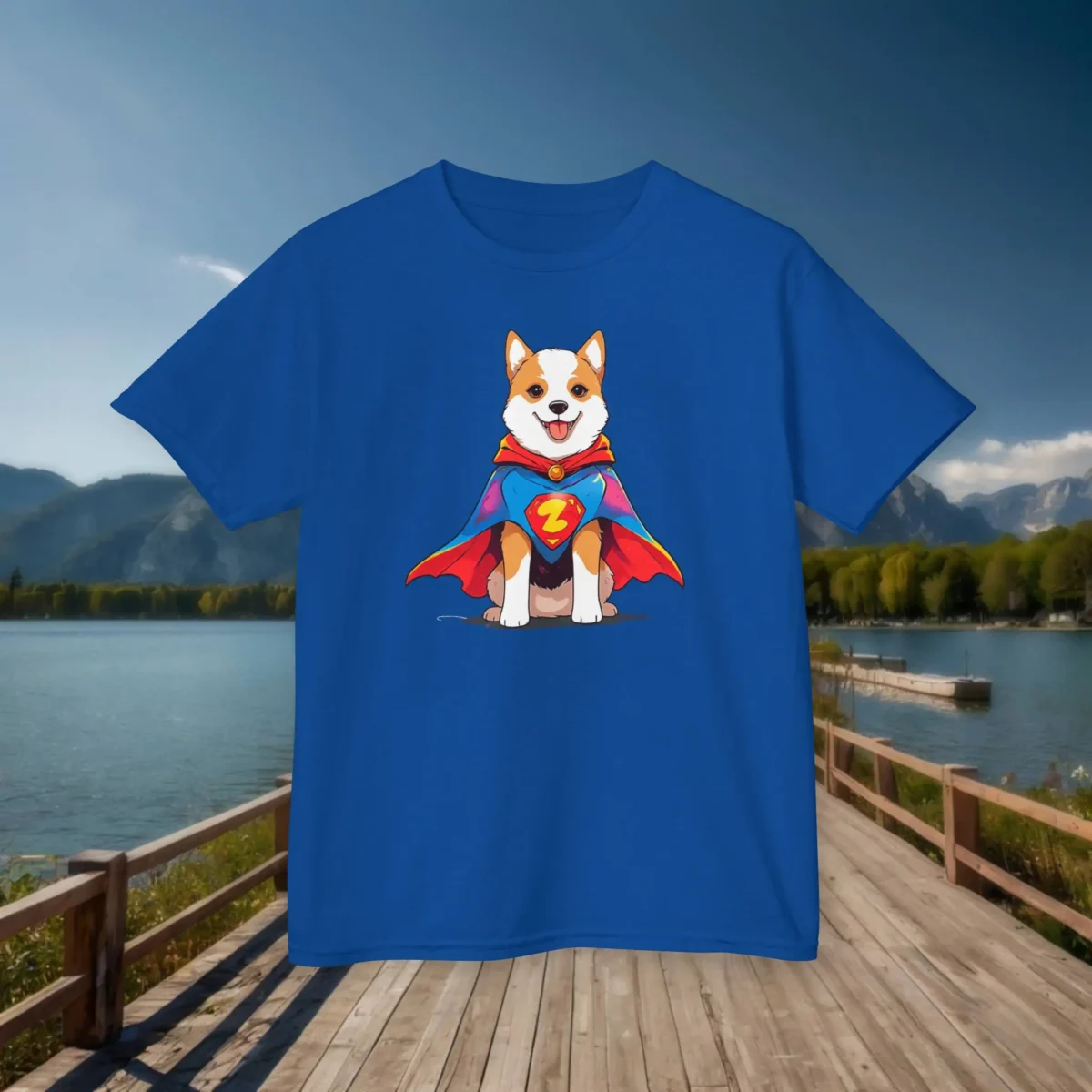 Flat lay of a royal blue kids t-shirt featuring a superhero corgi-style dog in a cape and emblem.