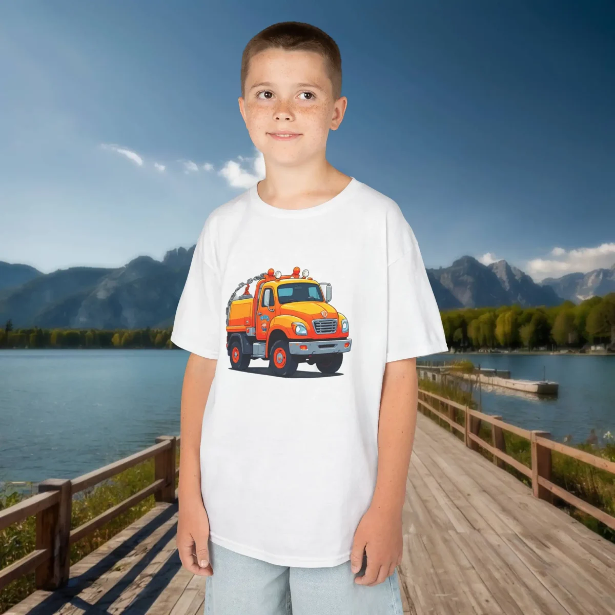 Smiling boy in white t-shirt featuring cartoon-style tow truck outdoors